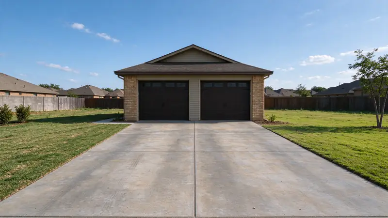 Two-car garage with a gray concrete driveway on a suburban lot