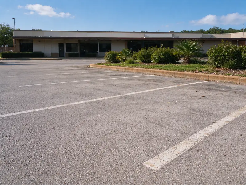 Faded but intact asphalt parking lot surface before sealcoating